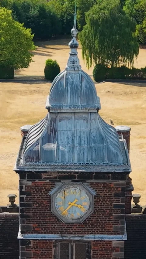 Aston Hall clock tower drone descent with parallax over drought-stricken formal Stock Footage 344094234