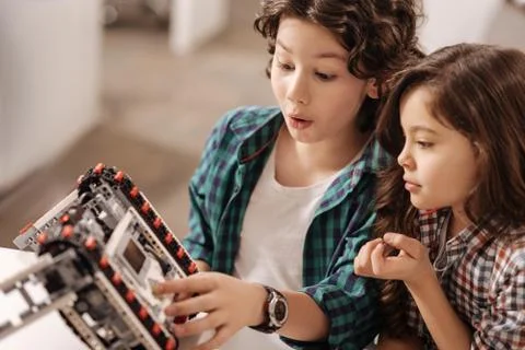 Astonished children programming robot in the science studio Foto stock