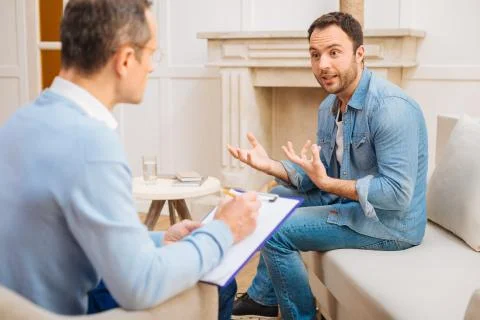 Astonished pretty man explaining his work troubles Stock Photos