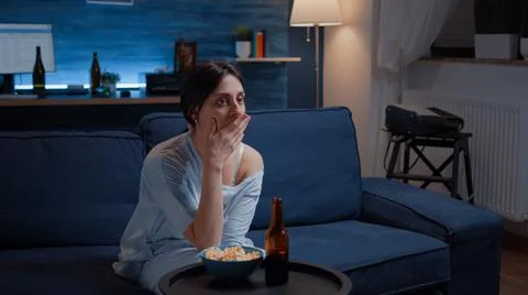 Astonished woman looking at movie at tv having surprised facial expression Stock Photos