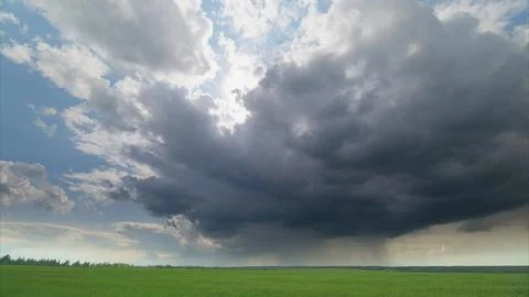 Astonishing and Dramatic Cloud Formation Looms Over Lush, Vibrant Green Fields B Stock Photos