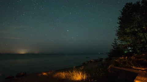 Astro Time Lapse Starry Sky with Green Airglow and Shooting Stars Over Bay Stock Footage 53853920