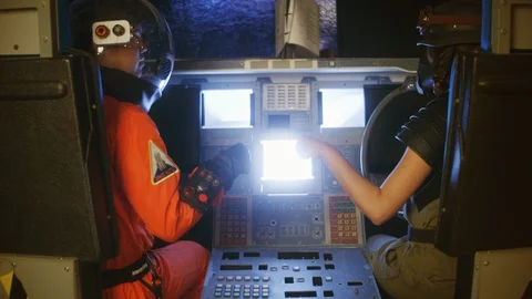 Astronaut and technician operating control board in cockpit Stock Footage 108960163