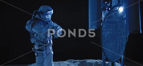 Astronaut checking equipment on Moon Stock Photos