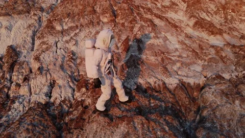 The astronaut climbs the rock with difficulty and then stops. aerial photography Vídeo Stock 159664937