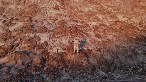 Astronaut dancing standing on a rock.the sun is shining. aerial photography Stock-Footage 159665786