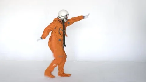 Astronaut dancing while wearing space suit with helmet on white background Stock Footage 258351357
