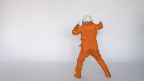 Astronaut dancing while wearing space suit with helmet on white background Stock Footage 258351416