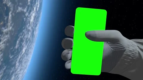 Astronaut floating in outer space holds a smartphone with a green screen display Video stock 311880159
