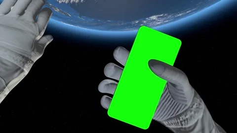 Astronaut floating in outer space holds a smartphone with a green screen display Video stock 311894151