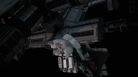 The astronaut floats smoothly to move in front of the station Stock Footage 260601113