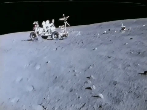 Astronaut John Watts Young drives a Lunar Roving Vehicle, bouncingly, kicking up Stock Footage 79458655