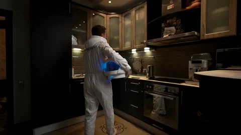 Astronaut in the kitchen is looking for something to eat in the refrigerator Video stock 220102547