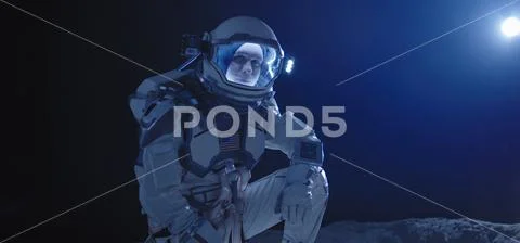Astronaut kneeling on the Moon Stock Photos