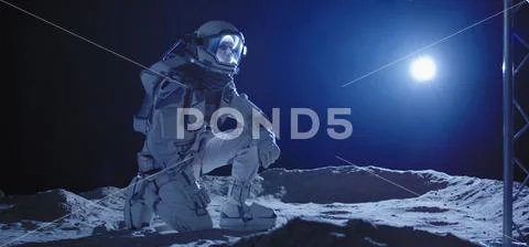 Astronaut kneeling on the Moon Stock Photos