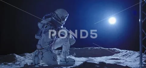 Astronaut kneeling on the Moon Stock Photos