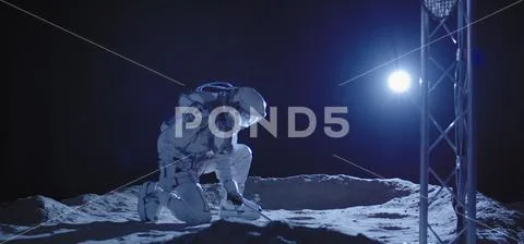 Astronaut kneeling on the Moon Stock Photos