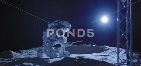 Astronaut kneeling on the Moon Stock Photos