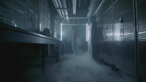 Astronaut in lab suit walking through smoky environment with science equipment Stock Footage 288432770