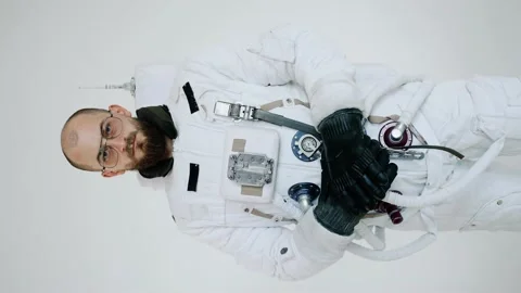 Astronaut on a light background with folded hands looking forward.vertical video Stock Footage 159663829