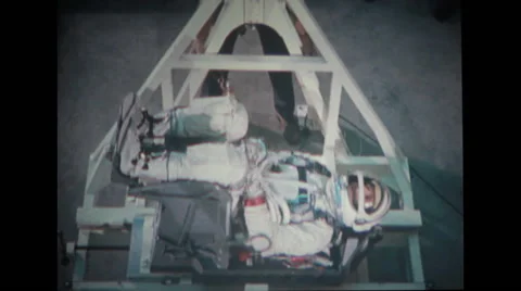 Astronaut lying in couch with technicians checking weight Stock Footage