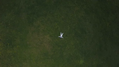 Astronaut lying on the grass looking at the sky Stock Footage 88920939