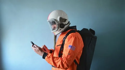 Astronaut man with astronaut helmet using smart phone 스톡 동영상 154532337