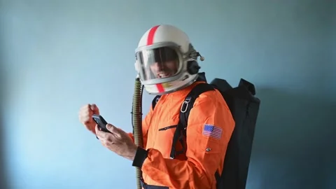 Astronaut man with astronaut helmet using smart phone Video stock 154532340