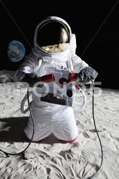 An astronaut on the moon connecting two cables Stock Photos