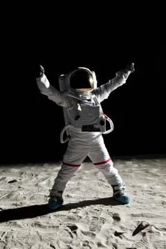 An astronaut on the moon with his arms raised in victory Stock Photos