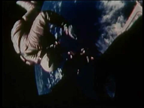 An astronaut pulling on a glove, showing his spacesuit, a handler helping him to Stock Footage 75287523