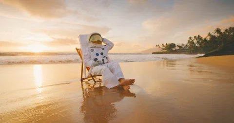 Astronaut relaxing on a beach far far away Stock Footage 127676145