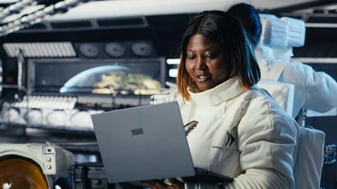 Astronaut returning from planet surface takes helmet off, talking with colleague Stock Photos