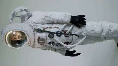 An astronaut with a serious face stands against a light background. vertical Vídeo Stock 159664853