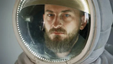 An astronaut with a serious face stands against a light background. studio 스톡 동영상 159782830