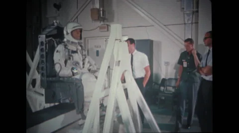 Astronaut sitting on couch with technicians observing Stock Footage 37597152