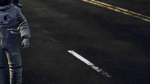 Astronaut in space suit stands on empty road at night with no vehicles Stock Footage 337875077