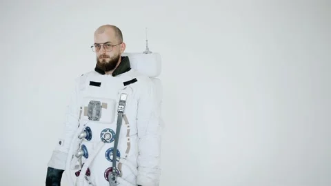 Astronaut stands on a light background with a serious expression on his face Video stock 159662910