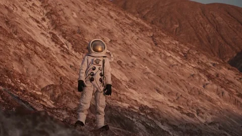 An astronaut stands on a rock and looks into the distance.camera moves at him Stock Footage 159664341