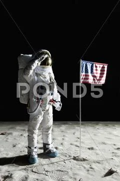 An astronaut on the surface of the moon saluting an American flag Stock Photos