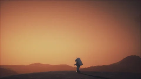 An Astronaut walking carefully on a moon called Titan in the afternoon Stock-Footage 240320548
