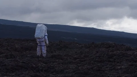 Astronaut walking in a Martian desolate landscape, Mauna Loa Volcano, Hawaii Stock Footage 104235318