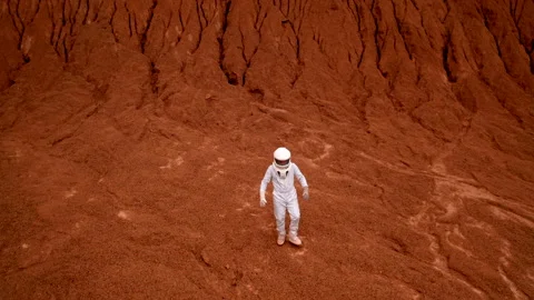 Astronaut walking on red planet surface to the aerial camera Stock Footage 222937859