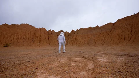 Astronaut walks on the surface of Mars to the boundary of the crater Vidéo 220103502