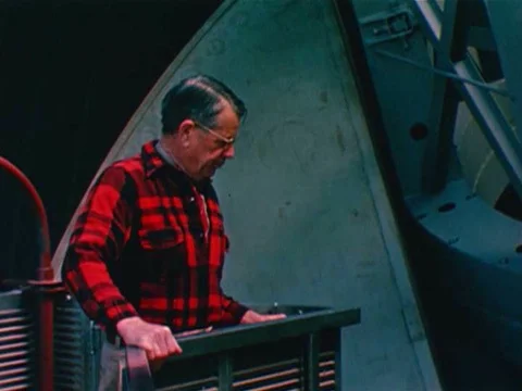 A astronomer rises in an elevator, stops and enters observer's cage to make Stock Footage 74947443