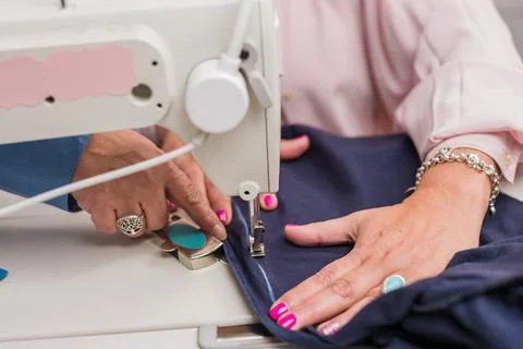 Atelier process needle detail. Unrecognizable woman hand on a sewing machine Stock Photos