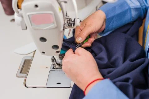 Atelier process needle detail. Unrecognizable woman hand on a sewing machine Stock Photos