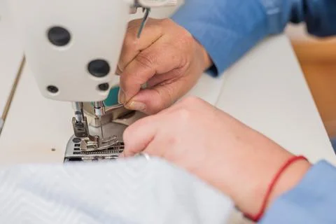 Atelier process needle detail. Unrecognizable woman hand on a sewing machine Stock Photos