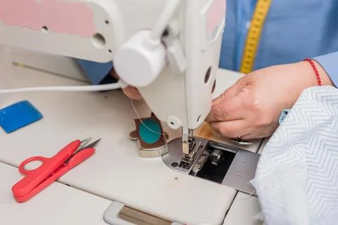Atelier process needle detail. Unrecognizable woman hand on a sewing machine Stock Photos