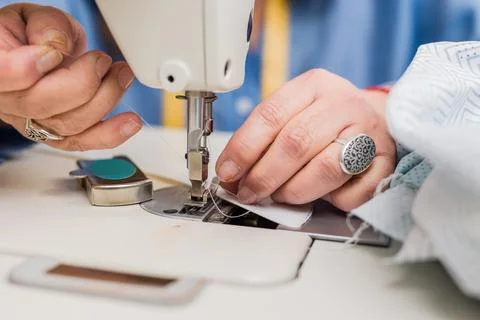 Atelier process needle detail. Unrecognizable woman hand on a sewing machine Stock Photos